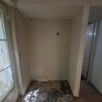 קיר צבוע עם רצפה מוכתמת ליד חלון