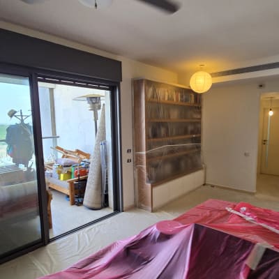 חדר עם רהיטים מכוסים בניילון לקראת צביעה