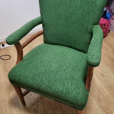 כיסא מרופד בירוק עם רגלי עץ על רצפת עץ