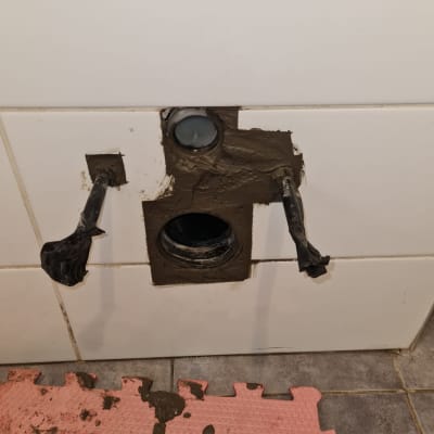 צינור ביוב פתוח בקיר עם תיקון טיח