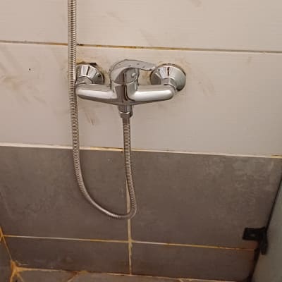 ברז מקלחת עם צינור ומרצפות קרמיקה