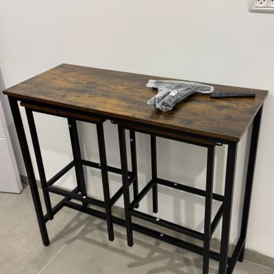 שולחן עץ עם רגלי מתכת וכלי עבודה על השולחן