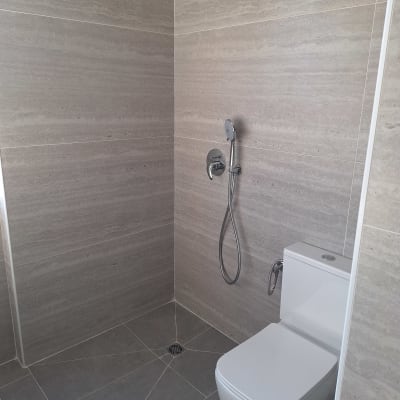 חדר אמבטיה עם מקלחת ושירותים מודרניים