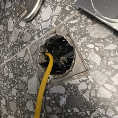 כבל צהוב בתוך חור ברצפה, כלי עבודה ליד