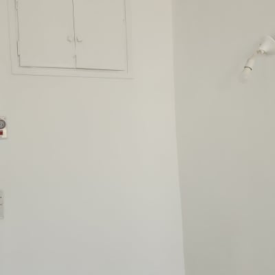 קיר צבוע בלבן עם מנורה ותקרה