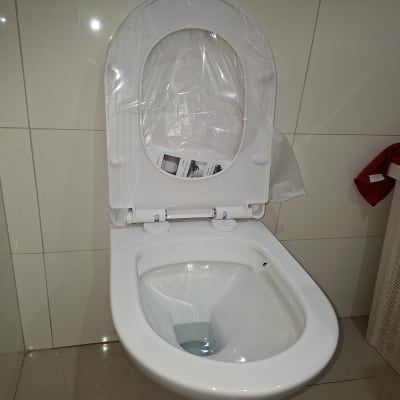 אסלה מותקנת עם כיסוי פלסטיק בחדר אמבטיה