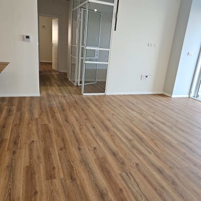 רצפה נקייה מעץ בחדר ריק עם דלת זכוכית