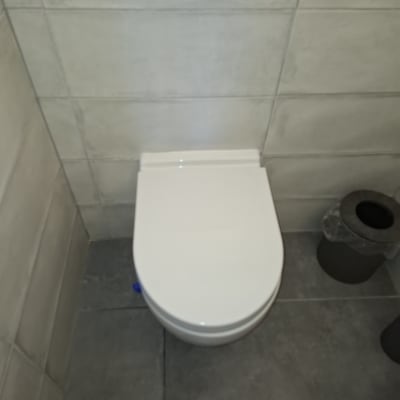 אסלה לבנה מותקנת על רצפת אריחים אפורה