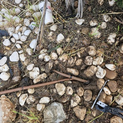 צינור מים שבור וכלי עבודה על אדמה