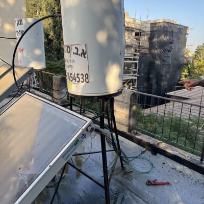 דוד שמש מותקן על גג עם צינורות וכלים