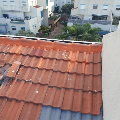 גג רעפים אדום עם תיקונים וכתמים