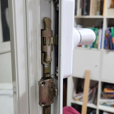 מנגנון נעילה של חלון או דלת עם ידית לבנה