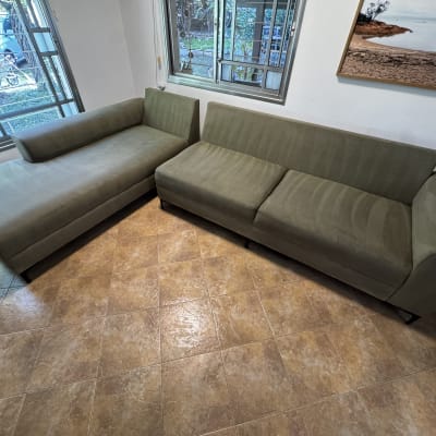 ספות ירוקות בחדר עם חלונות גדולים