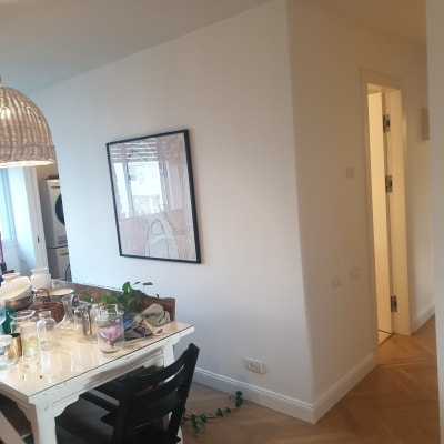 תמונה ממוסגרת של ציור מופשט תלויה על קיר לבן