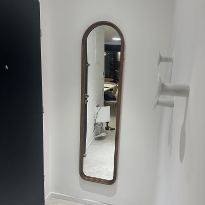 מראה תלויה על קיר עם כלי עבודה ברקע