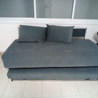 אדם מרכיב ספה בחדר עם חלון גדול