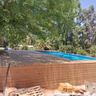 בריכת עץ עם דק עץ וסביבה עצים ירוקים