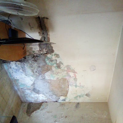 קיר עם נזקי רטיבות וסדקים, ללא כלים או פעולות של אינסטלטור.