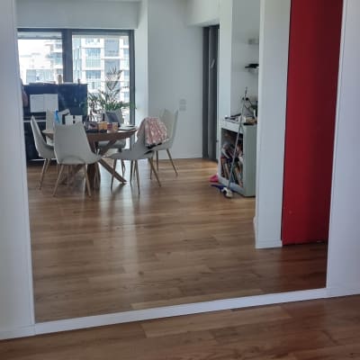 מראה גדולה על קיר בחדר עם רצפת עץ