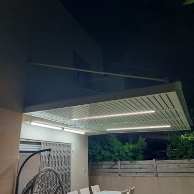 פרגולה מאלומיניום עם תאורה מובנית מעל שולחן חיצוני