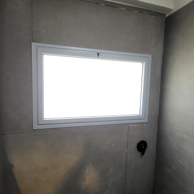 חלון אלומיניום על קיר אפור בחדר