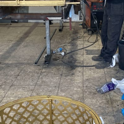 עובד מרתך מסגרת מתכת בסדנה