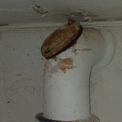 צינור חלוד עם מכסה מתכת בתקרה