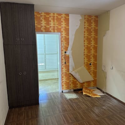 חדר עם טפט מתקלף ועבודות שיפוץ