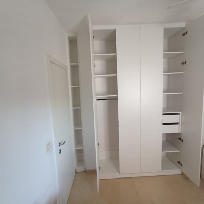 ארון לבן עם דלתות פתוחות ומדפים פנימיים