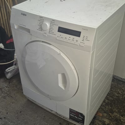 מייבש כביסה לבן עומד על רצפה מלוכלכת