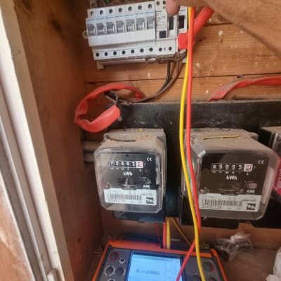 חשמלאי בודק לוח חשמל עם מד מתח