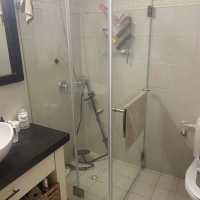 מקלחון זכוכית עם מגבות ותמרוקים
