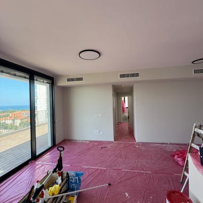 חדר עם ציוד צביעה ויריעות מגן על הרצפה