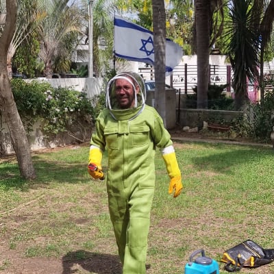 אדם בחליפת מגן ירוקה עם ציוד הדברה