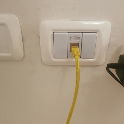כבל רשת צהוב מחובר לשקע קיר לבן