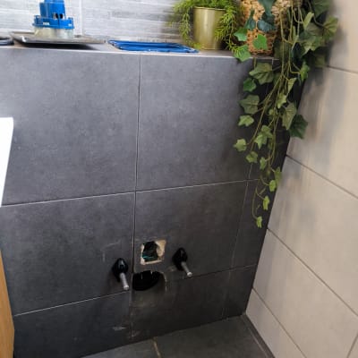 תמונה של קיר עם חור לצנרת וכלים לידו