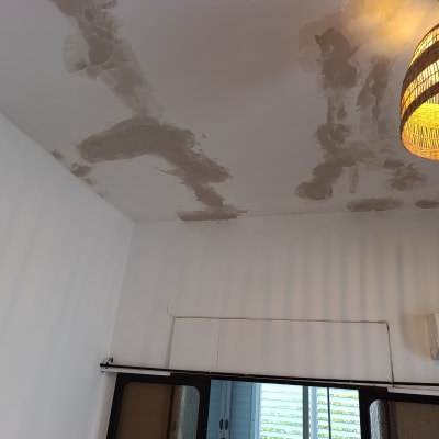 תיקוני טיח בתקרה עם מנורה תלויה