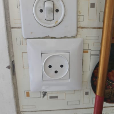 שקע חשמל על קיר עם טפט גיאומטרי