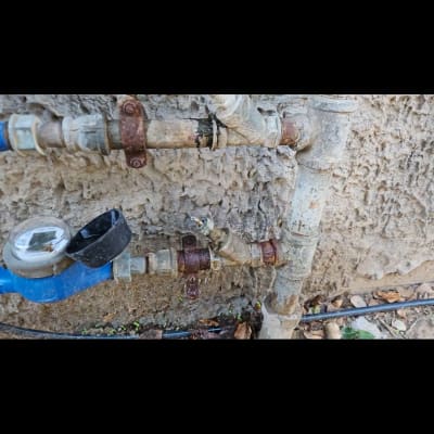 צינורות מים וחיבורים חלודים על קיר חיצוני