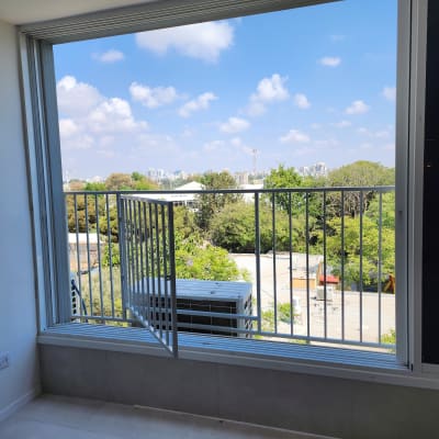 חלון גדול עם מסגרת מתכת ונוף חיצוני