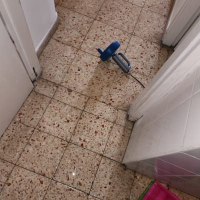 כלי עבודה כחול על רצפת קרמיקה רטובה