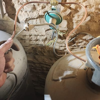 חיבורי גז וצינורות ליד קיר לבנים