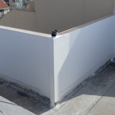 קיר לבן משופץ עם צינור ניקוז על גג