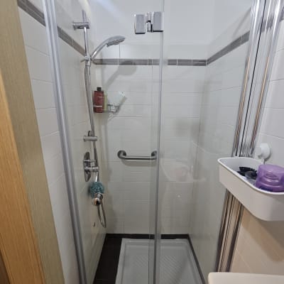 מקלחון עם דלת זכוכית ומקלחת יד