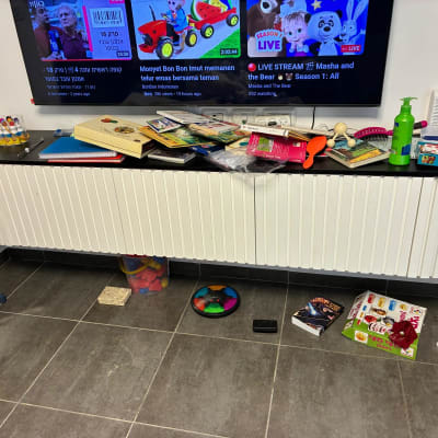 חפצים שונים על מדף מתחת לטלוויזיה