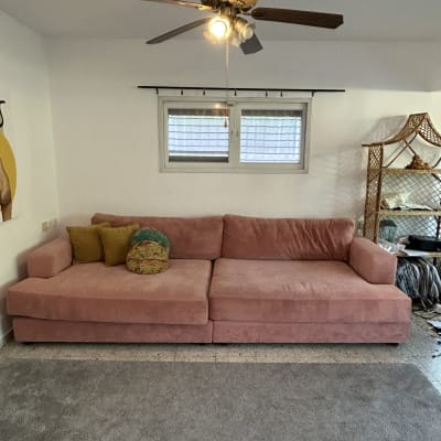 ספה ורודה עם כריות בחדר מגורים