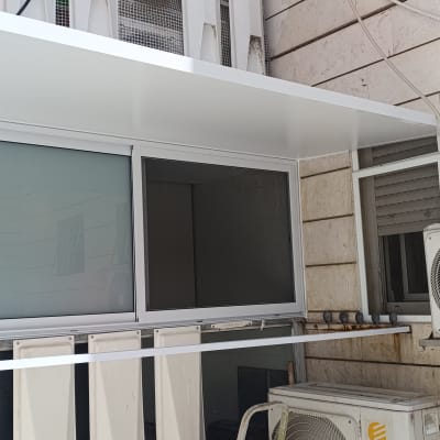 מרפסת אלומיניום עם מזגן על קיר חיצוני