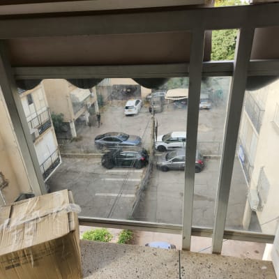 חלון זכוכית עם נוף לחניה ומכוניות