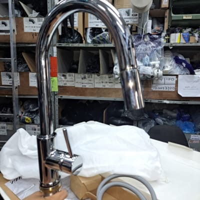 ברז כרום עם צינור גמיש ביד של אדם