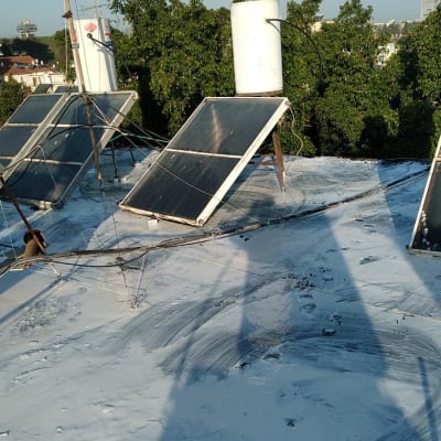 פאנלים סולאריים על גג עם חומר איטום לבן